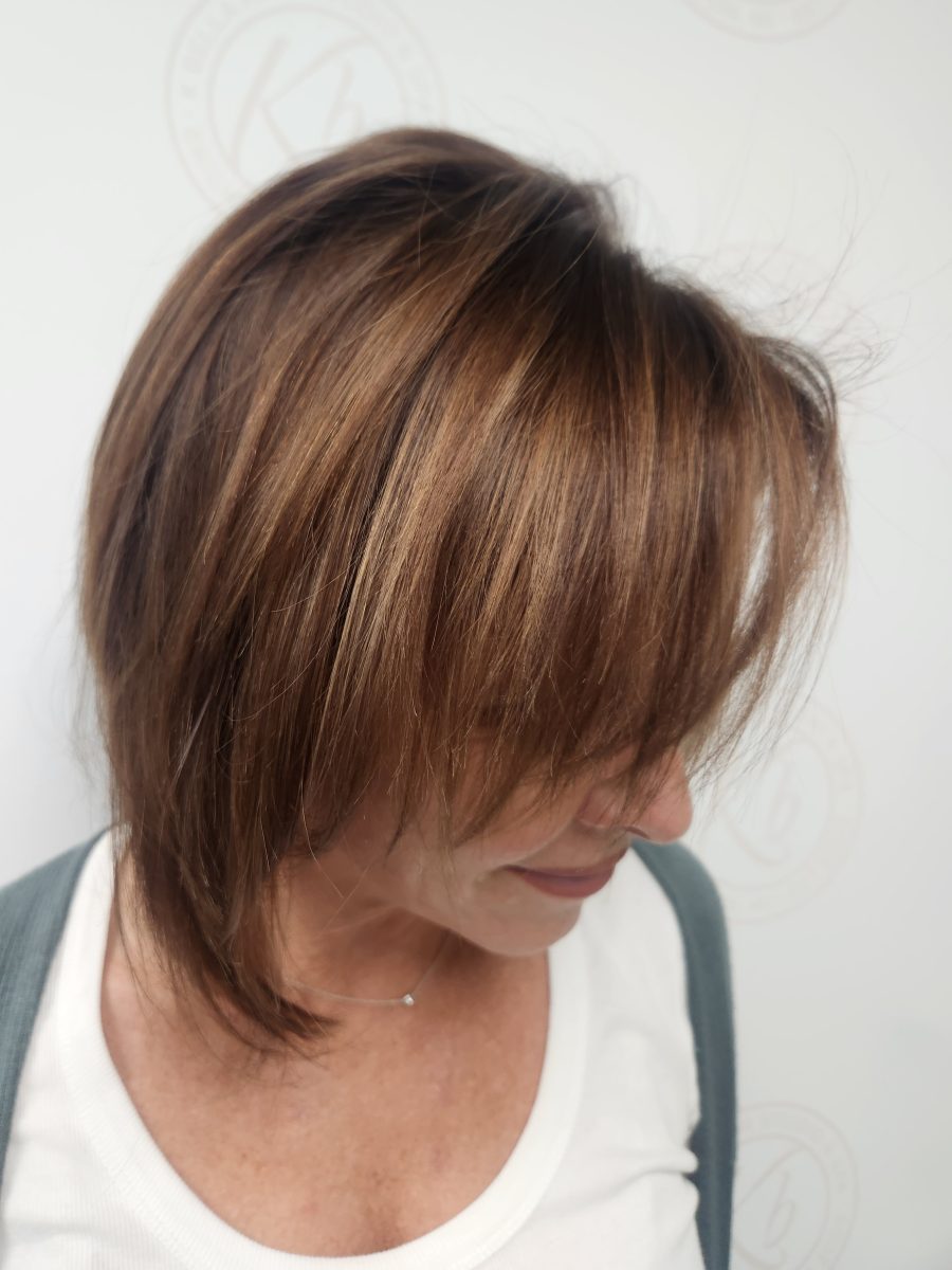 After photo: shoulder-length layered cut with richer brown tones, angled side view by Siobhan Rozinski at K Bella Hair Studio & Spa in Brighton, MI