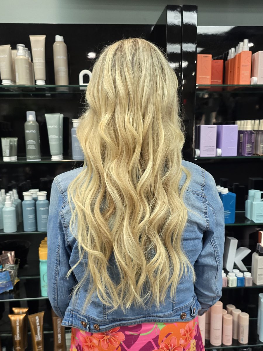 Back view of long platinum blonde wavy hair with extensions, by Kristan Sayers at K Bella Hair Studio & Spa in Brighton, MI