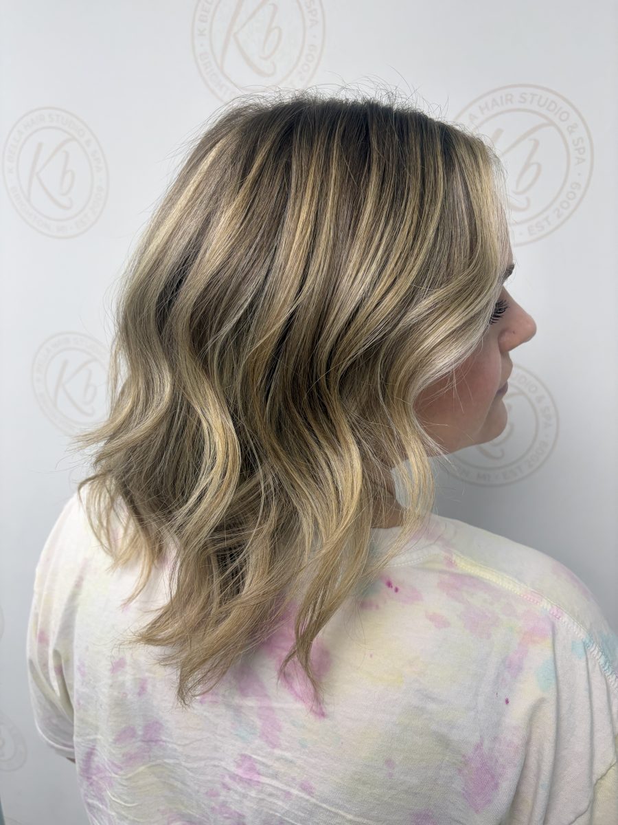 Profile view of finished balayage and layered cut showing dimension and movement by Abbey French at K Bella Hair Studio & Spa in Brighton, MI